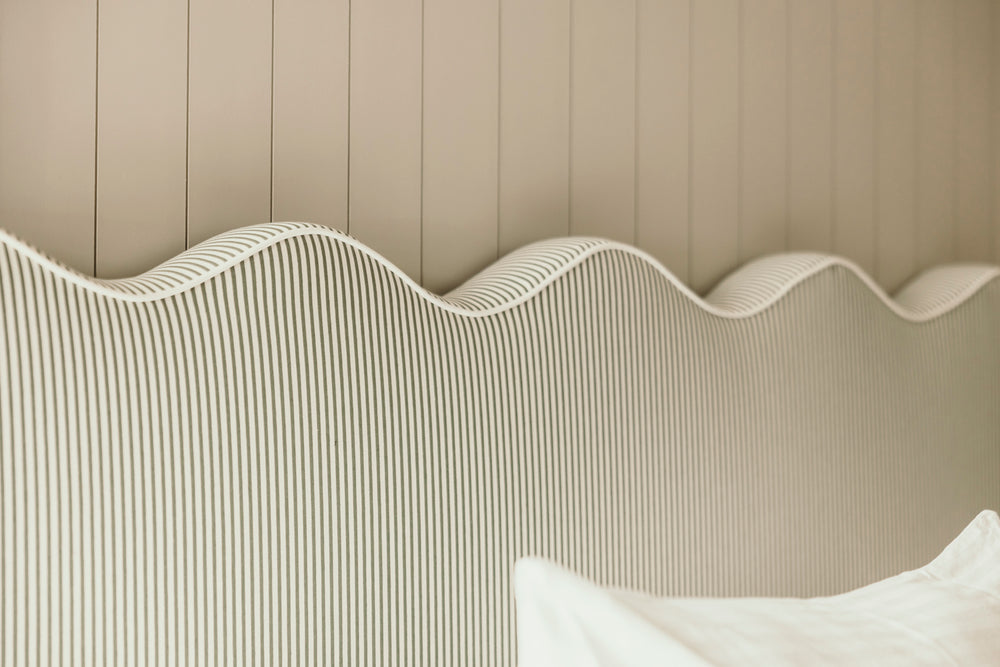 Textured headboard with wavy design against a beige wall