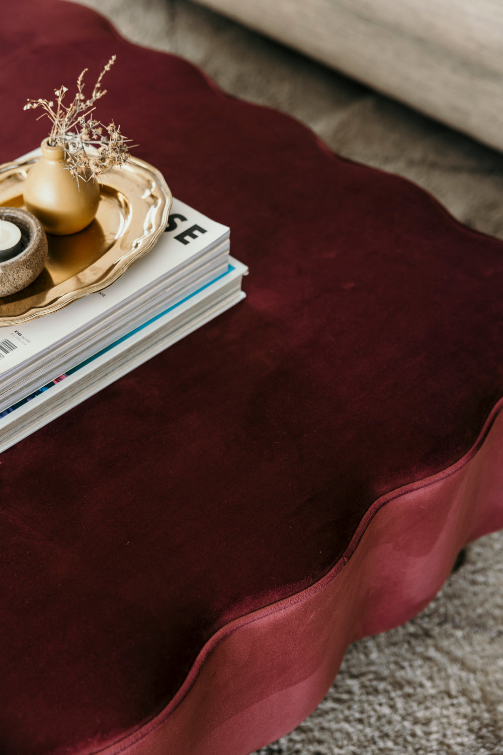 Mauve side table with decorative items including a gold teapot and books.