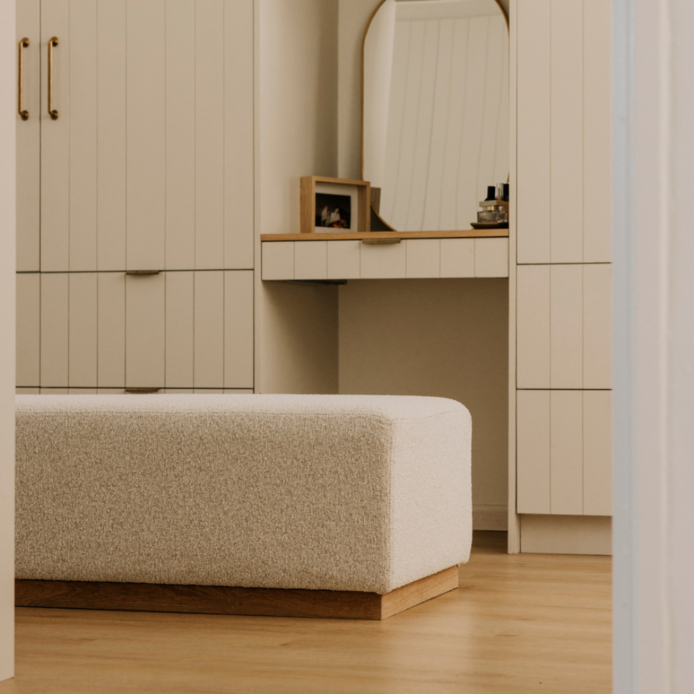 Beige wardrobe with a mirror and stool in a room setting