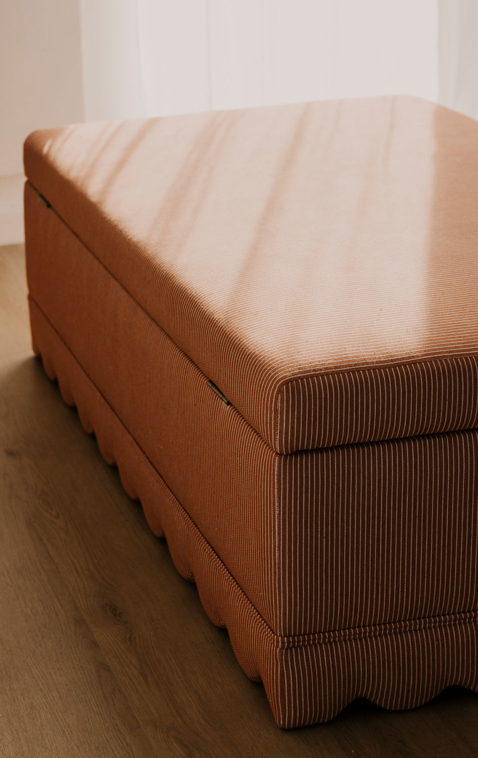 Brown mattress on a wooden floor with a neutral background