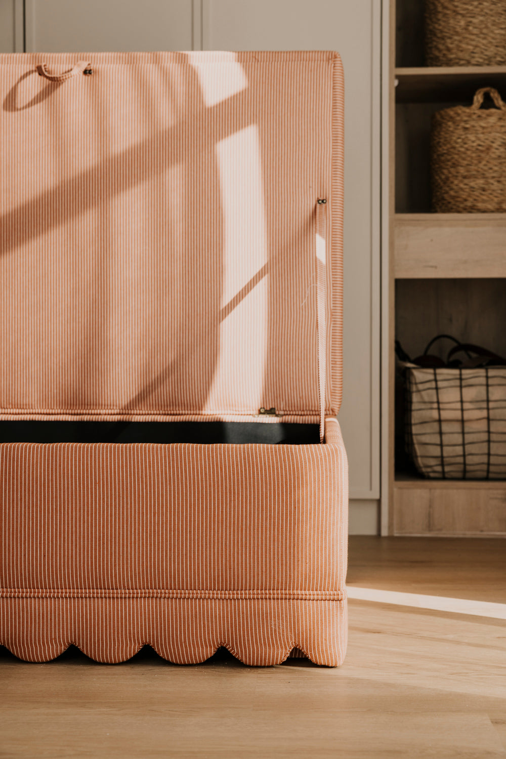 Brown ribbed storage unit with a black base against a neutral wall.