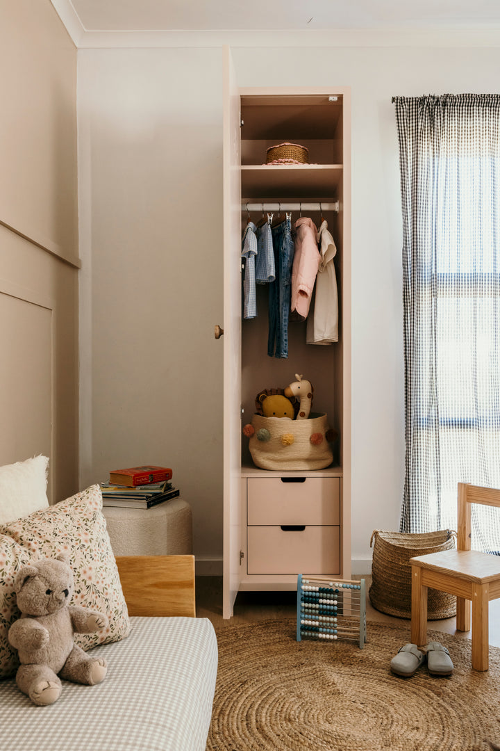 Children's room with a wardrobe, bed, and toys.