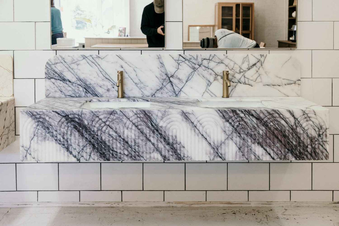 Marble-patterned bathtub in a bathroom setting with tiled walls.