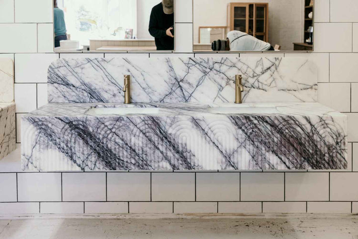Marble-patterned bathtub in a bathroom setting with tiled walls.