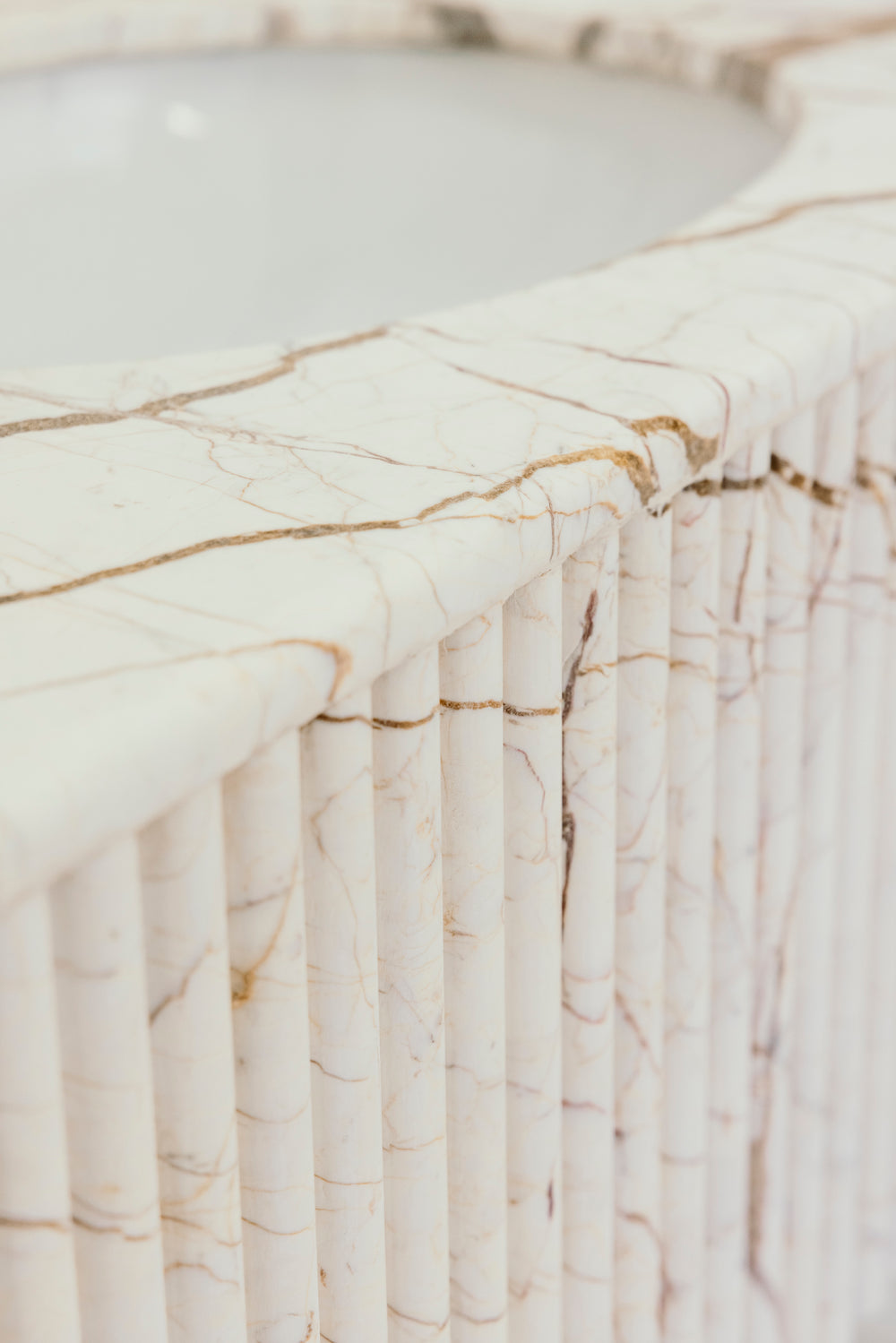 Close-up of a marble countertop with beige and brown veins.