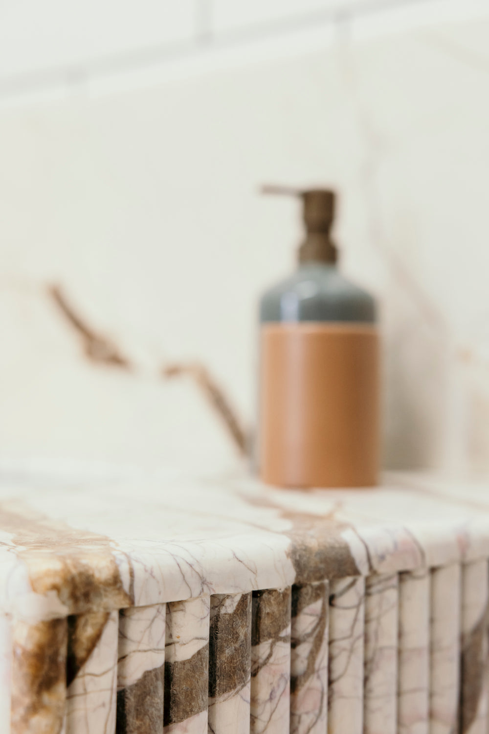 Brown bottle on a marble surface with a blurred background