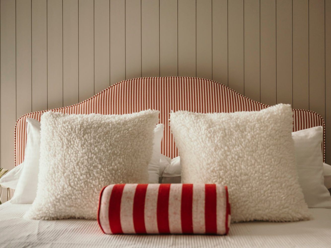 An upholstered Holly Wood headboard with cushions