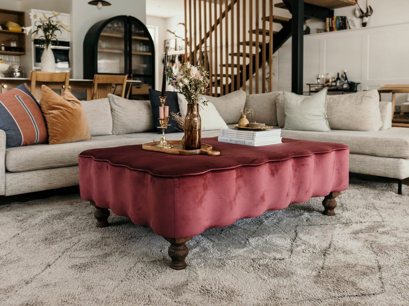 A boucle ottoman in a dressing room with fitted cabinetry and a mirror