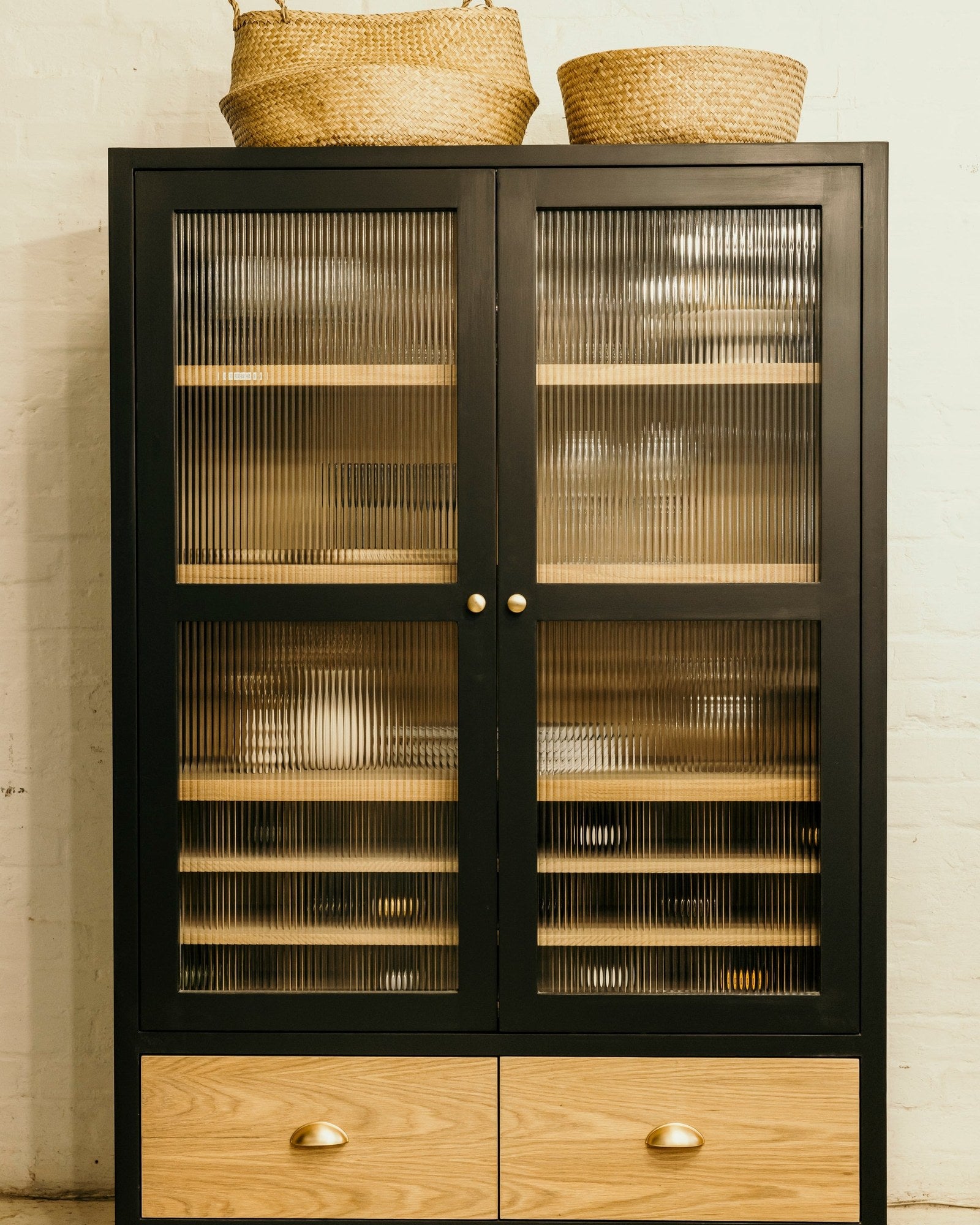 The Wine Bar, a black display cupboard with reeded glass doors and oak drawers, made by Holly Wood Design Studio